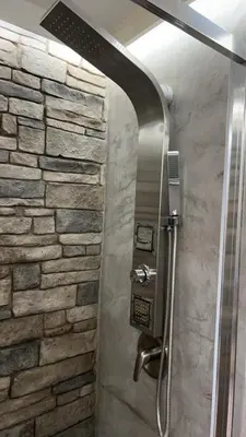 a shower in a bathroom with a stone wall at Walk on the riverside in Montréal
