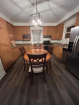 a kitchen with a table and chairs and a refrigerator at Walk on the riverside in Montréal