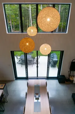 a room with a table with chairs and lights at Pur Nature et Spa Owl's Head in Mansonville