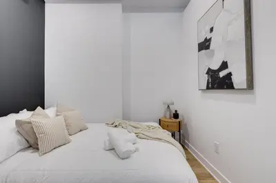 a white bedroom with a bed with white pillows at Le Mile End by M11 - Luxurious & Cozy 1BDR Unit in Montréal