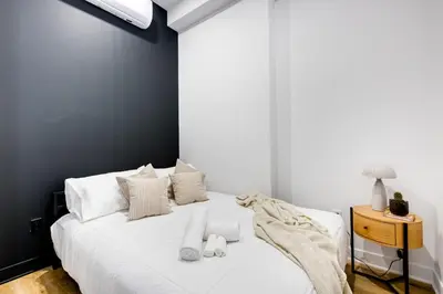 a bedroom with a white bed with a black wall at Le Mile End by M11 - Luxurious & Cozy 1BDR Unit in Montréal