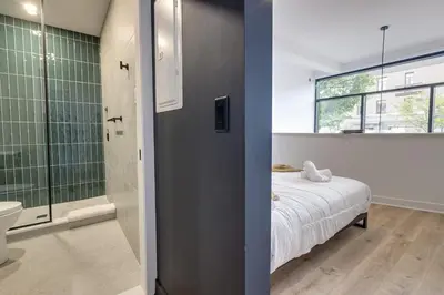 a bedroom with a bed and a bathroom with a shower at Le Mile End by M11 - 2 BDR Loft with Sofa Bed in Montréal