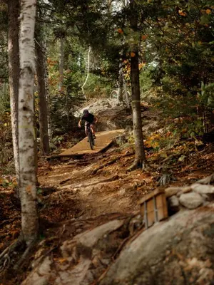 a person riding a bike on a trail in the woods at Chalet Le Hygge Hytte - Ski - Golf - Spa in Thetford Mines