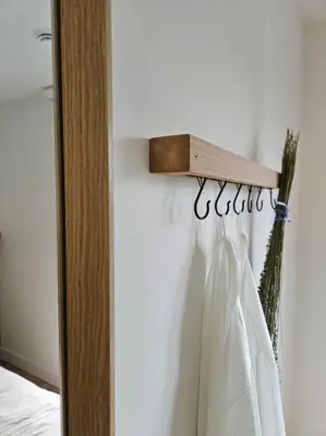 a towel rack with a dress hanging on a wall at Chalet Le Hygge Hytte - Ski - Golf - Spa in Thetford Mines