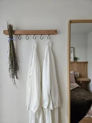 two white shirts hanging on a wall next to a mirror at Chalet Le Hygge Hytte - Ski - Golf - Spa in Thetford Mines