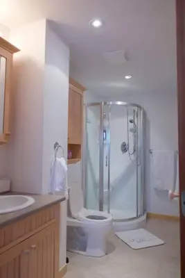 a bathroom with a shower and a toilet and a sink at Chalet familial et SPA à proximité du Mont Orford in Orford