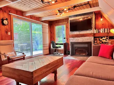 a living room with a couch and a fireplace at Chalet tout inclus avec SPA près du Mont Orford in Orford