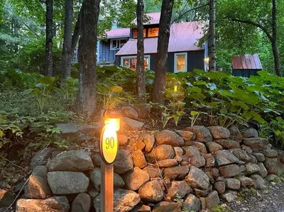 a light in a pile of rocks in front of a house at Chalet tout inclus avec SPA près du Mont Orford in Orford