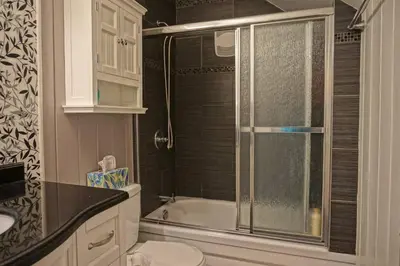 a bathroom with a shower and a toilet and a sink at Chalet tout inclus avec SPA près du Mont Orford in Orford