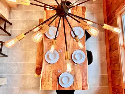 a chandelier with plates and utensils on a table at Chalet tout inclus avec SPA près du Mont Orford in Orford