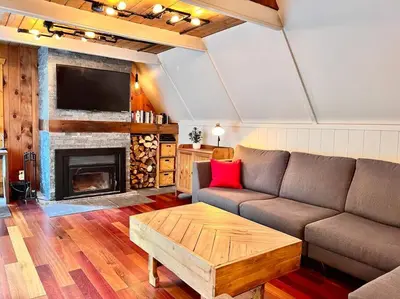a living room with a couch and a fireplace at Chalet tout inclus avec SPA près du Mont Orford in Orford