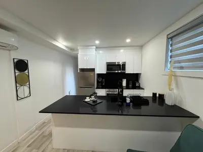 a kitchen with a black counter top in a room at Le Rêve Montréal! New & Modern! Easy Access Downtown & Attractions! in Montréal