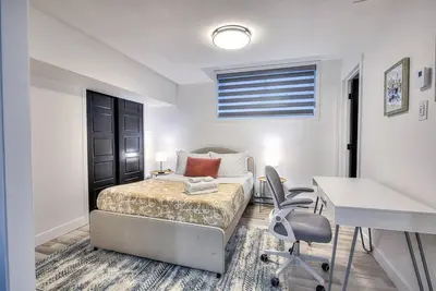 a bedroom with a bed and a desk and chairs at Le Rêve Montréal! New & Modern! Easy Access Downtown & Attractions! in Montréal