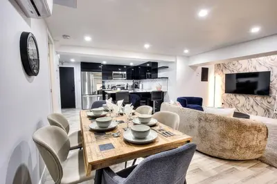 a dining table and chairs in a living room at Le Rêve Montréal! New & Modern! Easy Access Downtown & Attractions! in Montréal