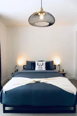a bedroom with a blue bed and a light at Pur Nature et Spa Eastman in Eastman