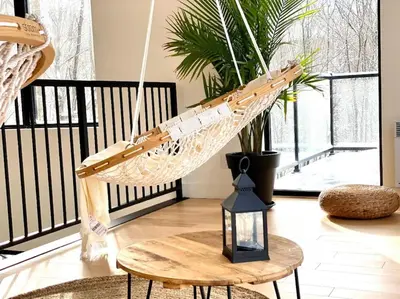 a hammock hanging from a table in a room with a porch at Pur Nature et Spa Eastman in Eastman