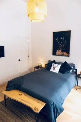 a bedroom with a blue bed with a table on it at Pur Nature et Spa Eastman in Eastman