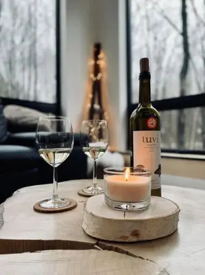 a bottle of wine and two glasses on a table at Pur Nature et Spa Eastman in Eastman