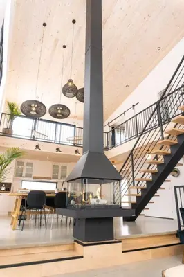a living room with a staircase and a fireplace at Pur Nature et Spa Eastman in Eastman