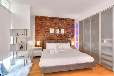 a bedroom with a bed and a brick wall at Take a break in a modern loft on Plateau-Mont-Royal in Montréal