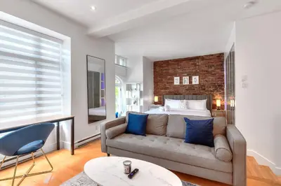 a living room with a couch and a bed at Take a break in a modern loft on Plateau-Mont-Royal in Montréal