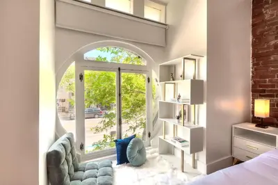 a bedroom with a bed and a large window at Take a break in a modern loft on Plateau-Mont-Royal in Montréal