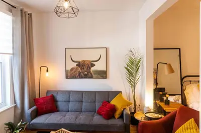 a living room with a couch and a bull on the wall at Appartement au coeur de Villeray in Montréal
