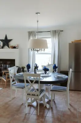 a dining room with a table and chairs and a refrigerator at Etoile bleue Beach bike shops Magog-Orford in Magog-Orford