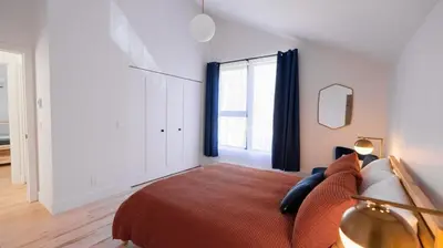 a bedroom with a bed and a large window at Le Bois Debout - Lake & Trails in Eastman
