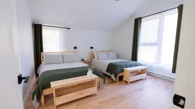 a bedroom with two beds and a large window at Le Bois Debout - Lake & Trails in Eastman