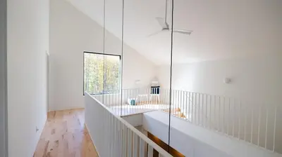 a white bathroom with a sink and a window at Le Bois Debout - Lake & Trails in Eastman