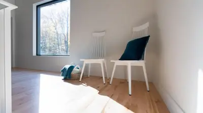 a room with two white chairs and a window at Le Bois Debout - Lake & Trails in Eastman