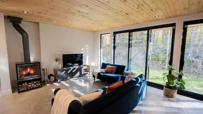 a living room with two couches and a fireplace at Le Bois Debout - Lake & Trails in Eastman