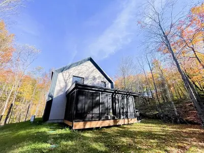 a small house in the middle of a field at Le Bois Debout - Lake & Trails in Eastman