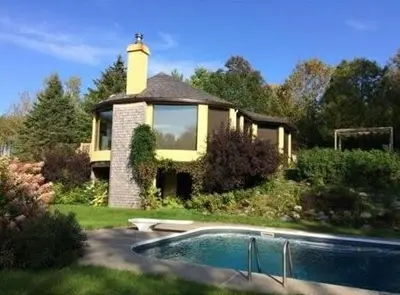 a house with a swimming pool in front of it at L'Orford VIEW POOL TENNIS SPA in Orford