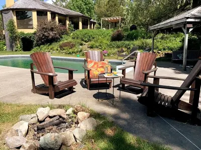 three chairs and a table next to a pool at L'Orford VIEW POOL TENNIS SPA in Orford
