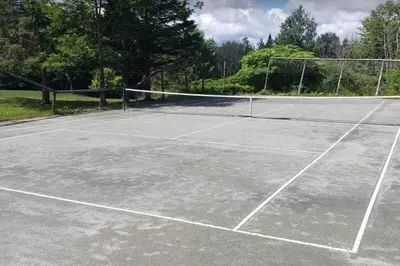 a tennis court with a net on top of it at L'Orford VIEW POOL TENNIS SPA in Orford