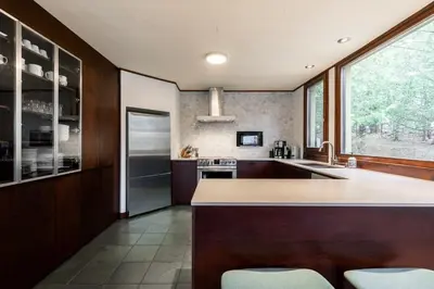 a kitchen with a counter and a large window at L'Orford VIEW POOL TENNIS SPA in Orford
