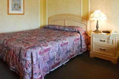 a bedroom with a bed and a night stand with a lamp at Hôtel Travelodge by Wyndham Victoriaville in Victoriaville
