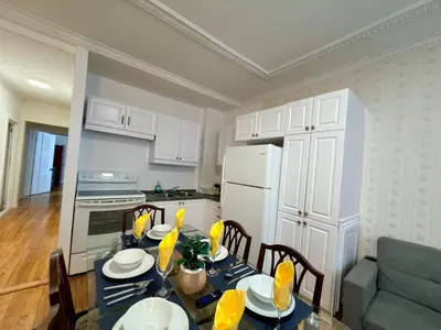 a kitchen with a table with chairs and a white refrigerator at Relaxation Retreat Unit in Montréal