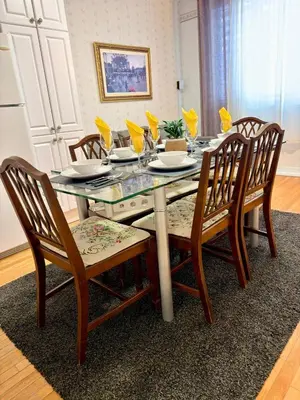a dining room table with four wooden chairs and a glass tableablish at Relaxation Retreat Unit in Montréal