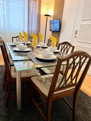 a dining room table with chairs and plates and glasses at Relaxation Retreat Unit in Montréal