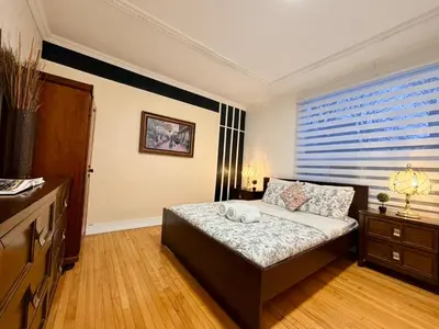 a bedroom with a bed and a dresser and a window at Relaxation Retreat Unit in Montréal