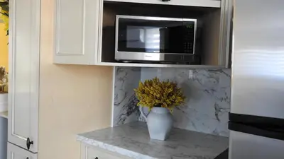 a kitchen with a microwave and a vase with flowers at Feels like a Home ,Away from Home ! in Montréal