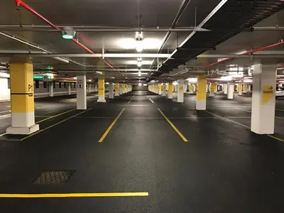 an empty parking garage with yellow and white columns at Downtown Central Residences in Montréal