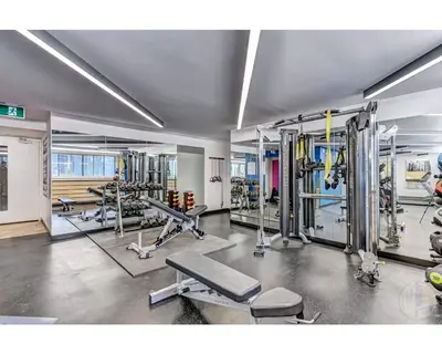 a gym with several treadmills and machines at Downtown Central Residences in Montréal