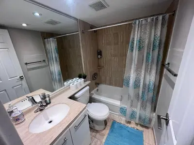 a bathroom with a sink and a toilet and a tub at Downtown Central Residences in Montréal