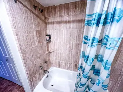 a bathroom with a tub and a shower with a shower curtain at Downtown Central Residences in Montréal