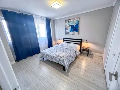 a bedroom with a bed and blue curtains in it at Downtown Central Residences in Montréal