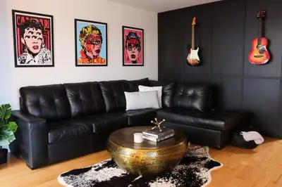 a living room with a black leather couch and a table at Luxury Artist Condo In Montreal in Montréal